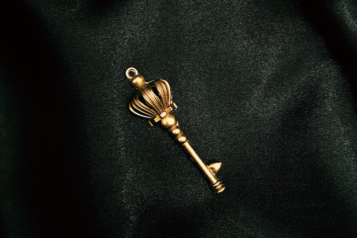 A single ornate gold key resting on dark fabric, representing the one trusted Golden Customer Record drawn from many source systems