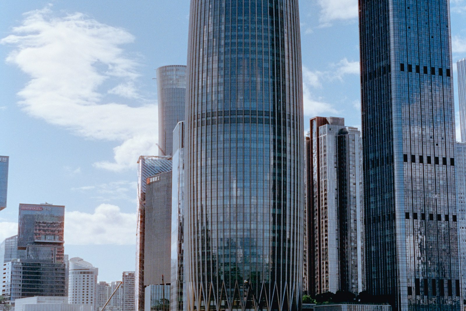 A modern waterfront skyline of glass towers and mixed-use development, representing the built-environment portfolio the platform runs